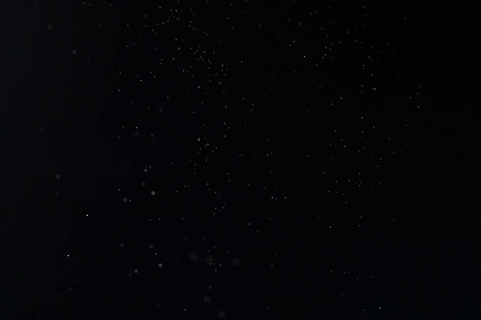 Tiny White Dust Particles on Black Background